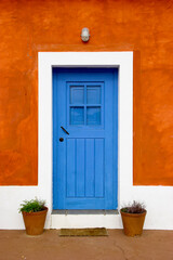 Fototapeta na wymiar Beautiful and funny orange house with blue doors and windows