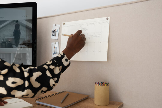 Black businesswoman writing information in schedule - Powered by Adobe