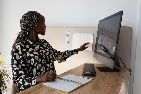 Black pregnant remote worker checking work schedule