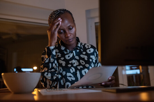 Exhausted black businesswoman working with papers