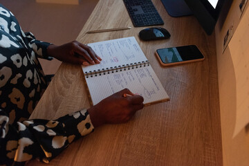 Crop black female entrepreneur making plan