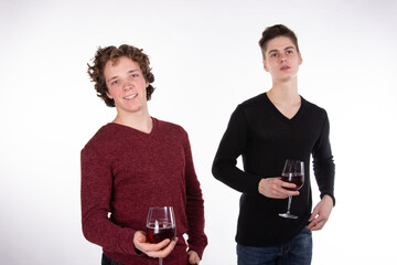 Two young attractive guys are drinking red wine. White background.