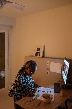 Focused black web designer analyzing diagrams
