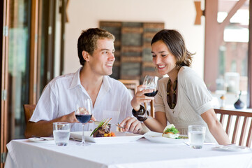 A young couple sitting at a table at an outdoor restaurant