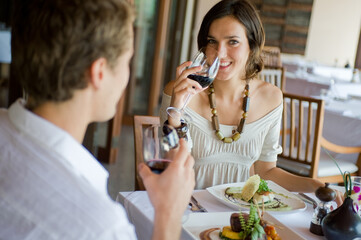 A young couple sitting together in a sophisticaed restaurant