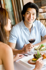 A young man enjoying wine with his meal