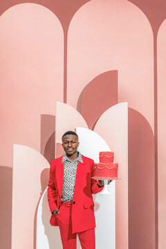 Portrait of a fashionable smiling guy with a cake in his hands