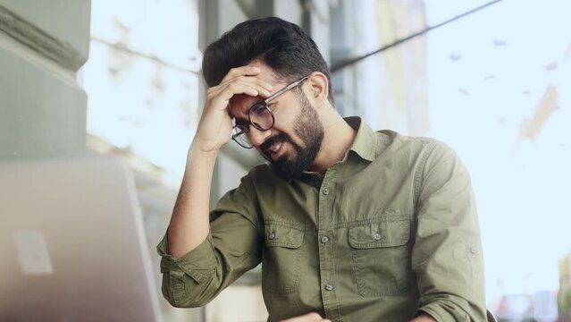 Worried young indian businessman freelancer waiting for important message with crossed fingers and reading bad negative news feeling disappointed upset and shrugs at city cafe Disappointment concept 