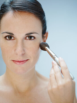 close up of woman applying fard on chins. Copy space