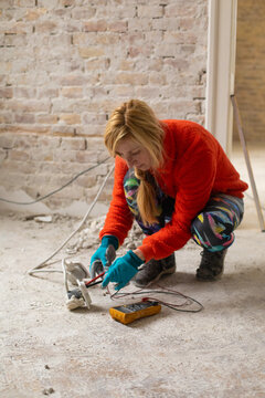 A female electrician is checking the power supply, the voltage