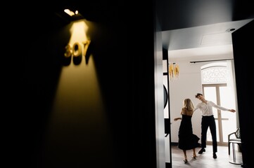 Joyful couple performing dance in hotel room
