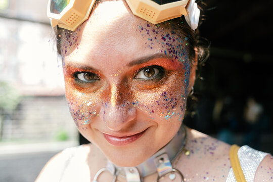 Cheeky woman with glitter make up looking at camera