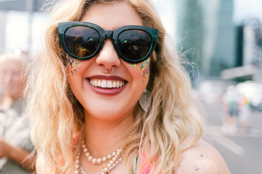 Proud and Glittering blond woman in sunglasses smile a camera