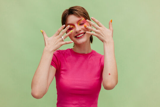 Happy woman showing fingers with nail art in studio