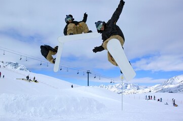 a serie of a snowboarder jumping high through a blue sky