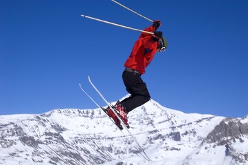 a skier jumping high through a blue sky