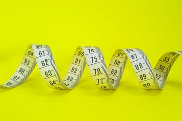 measuring tape against a yellow background