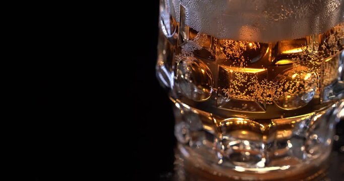 Beer in the glass. Alcohol. Fresh light beer passes behind the glass of beer, air bubbles can be seen in the glass. Advertising shot for packshot.