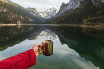 Point of view of person's hand with coffee cup outdoors