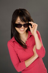 Portrait of a beautiful Asian teenager posing on a gray background