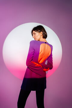 Back view of woman in purple dress looking over shoulder