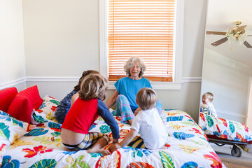 Grandma storytelling grandchildren in bed