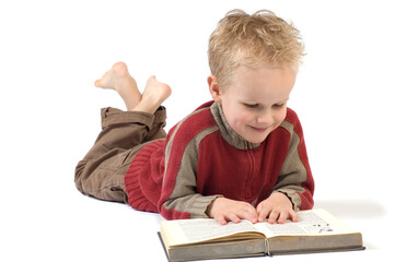 5 year old reading a book, isolated on white. Book is an old children's Bible.