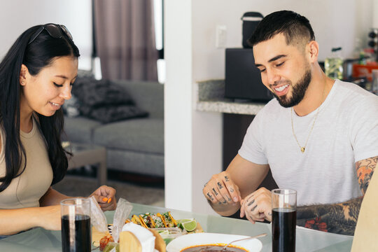 A man and a woman eating tacos.