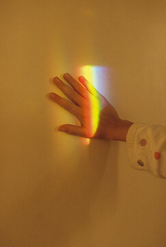 A kid's hand with rainbow light