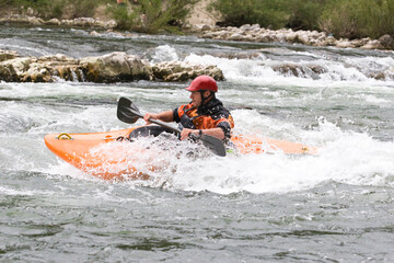 whitewater kayaker surfing a wave on grade 3 rapid