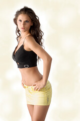 sensual brunette with short yellow skirt and a black top in model pose