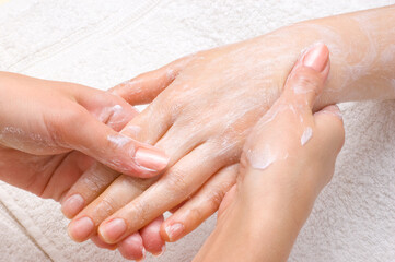 Obraz na płótnie Canvas applying peeling scrub or moisturizing cream onto the hands