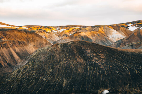 Colored textures of mountains layers and cooled lava field 