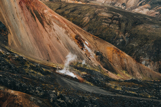 Colored textures of mountains layers and cooled lava field 