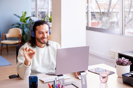 Cheerful male worker using laptop in modern workspace
