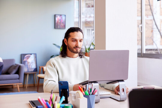 Positive man working on laptop in office