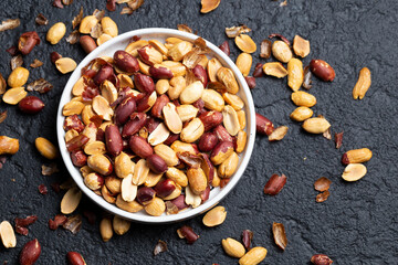 Pile of roasted peanuts on black background, space for text