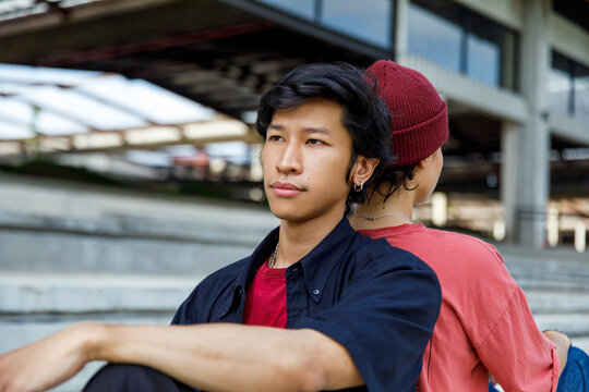 Couple sitting back-to-back outdoors in the city