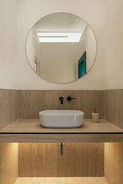 Modern clinic bathroom design with circular sink and mirror
