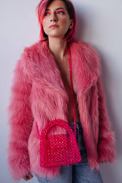 Trendy woman in pink fake fur coat with extravagant make up