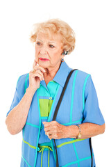 Worried looking senior woman talking on the hands free set for her cellphone.  Isolated on white.
