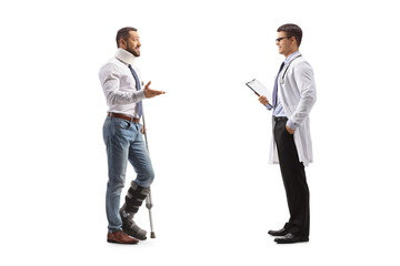 Obraz premium Injured male patient with an orthopedic boot and cervical collar talking to a male physician