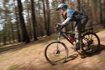Fototapeta na wymiar Woman-biker blurred in motion. Cross-country.
