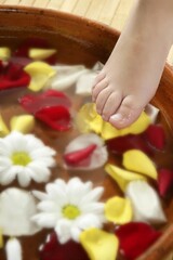 Obraz na płótnie Canvas Aromatherapy, flowers children feet bath, colorful rose petal