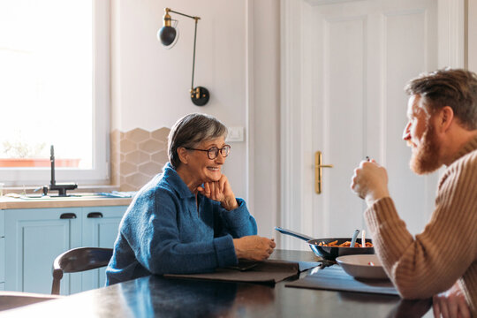 Senior Woman and Young Man Having Lunch