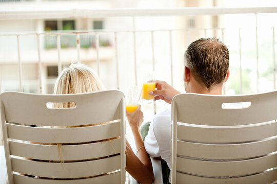 Rear view of young man and lady relaxing in balcony
