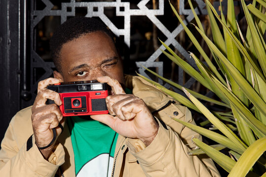 black man with vitiligo holds a film camera