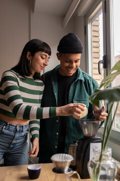 Happy couple making coffee at home