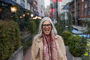 Stylish woman outside wearing jacket and scarf in winter.