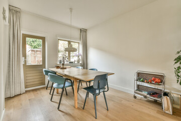 a dining table and chairs in a room with white walls, hardwood flooring and large windows overlooking the garden